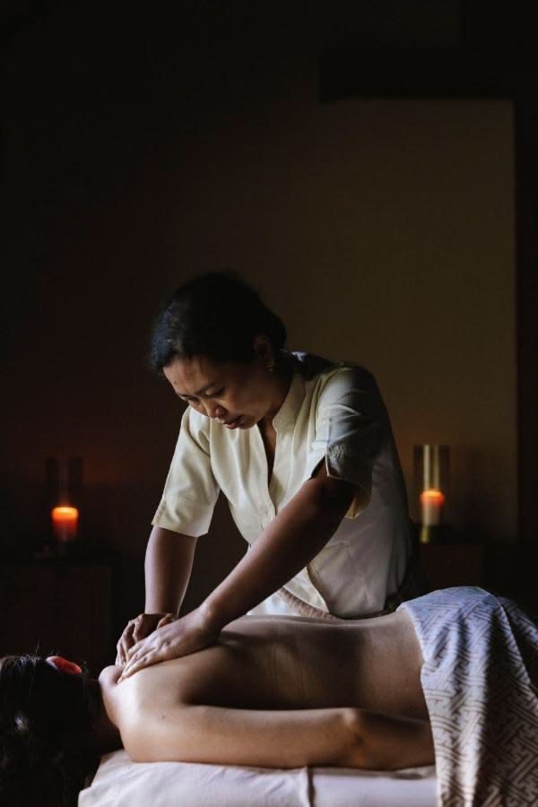 Terapeut mitt i en lugn massagebehandling i dämpat ljus