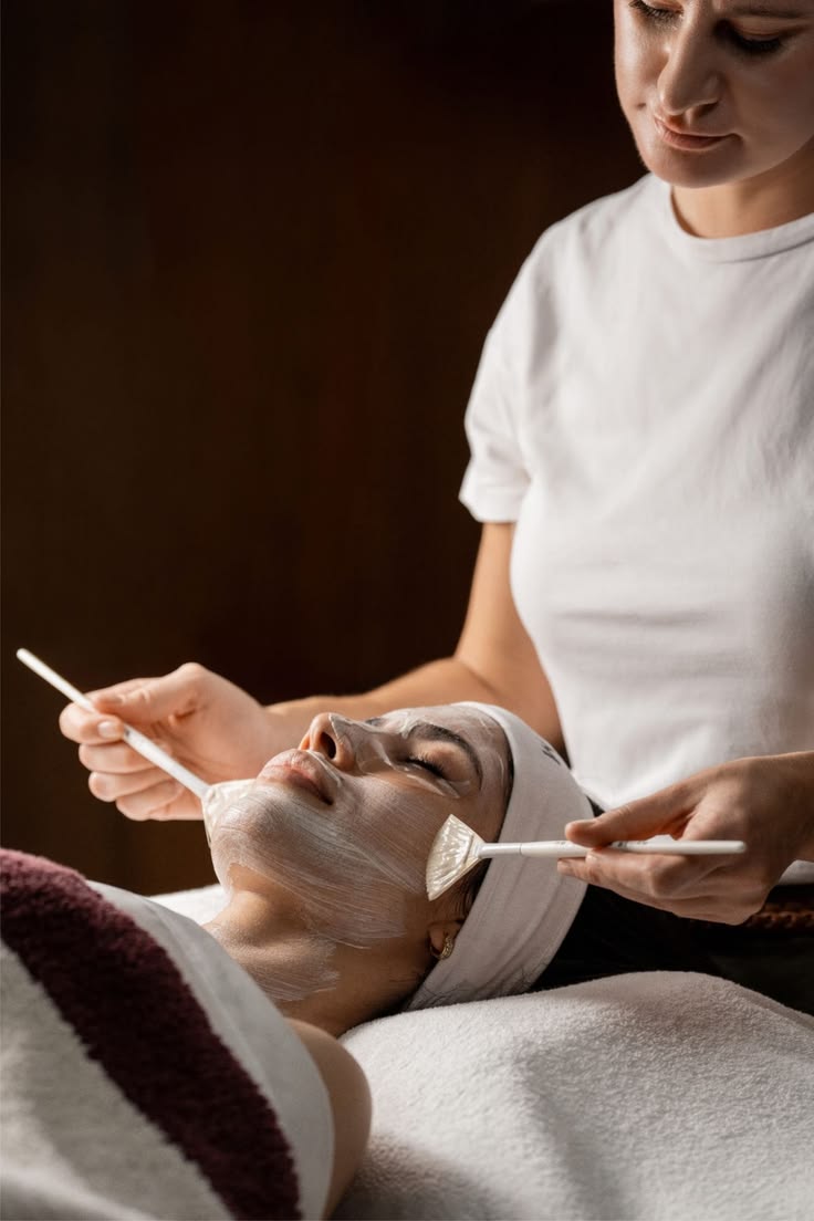 Behandlare applicerar en ansiktsmask med precision och omsorg