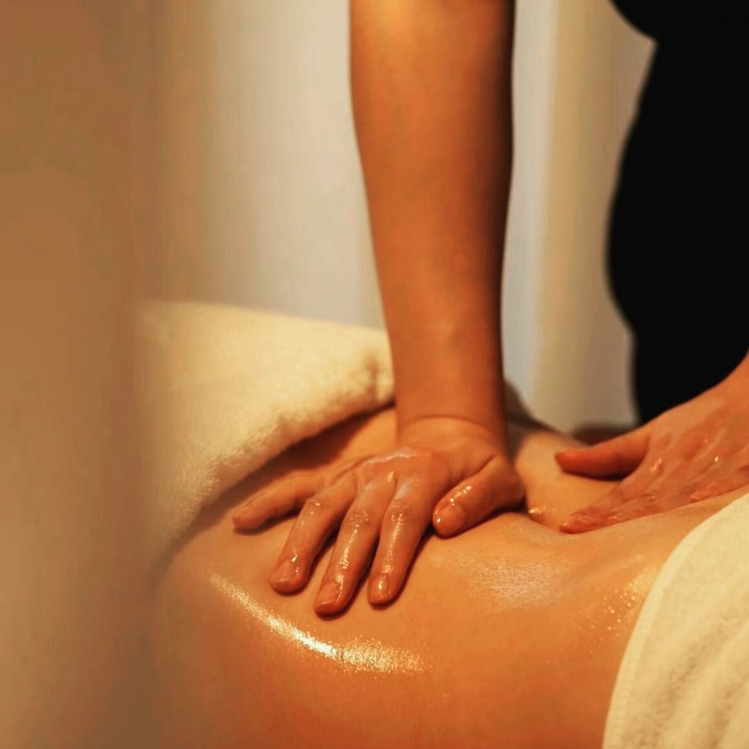Varsam oljemassage av rygg och axlar i dämpad belysning